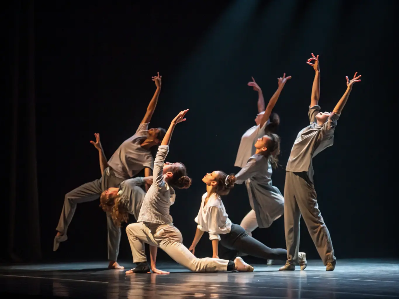 A photograph depicting a contemporary dance performance in a dimly lit studio, showcasing the fluidity and emotion of the dancers.